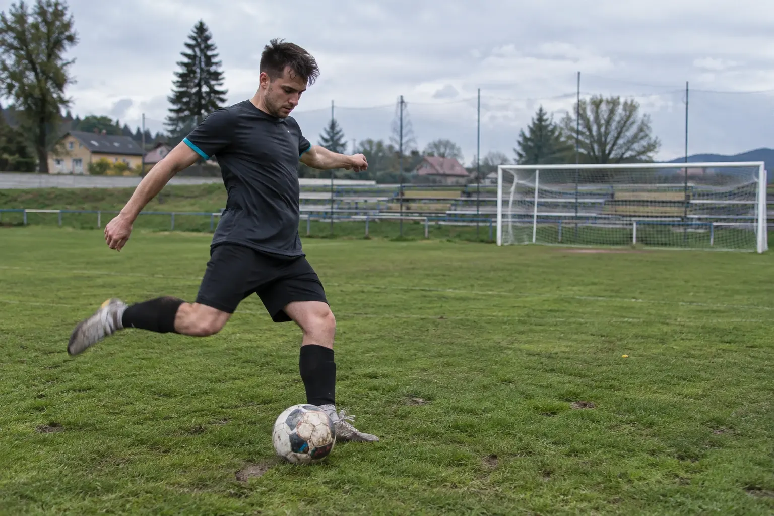 Futbalista pri strele počas tréningu na trávniku